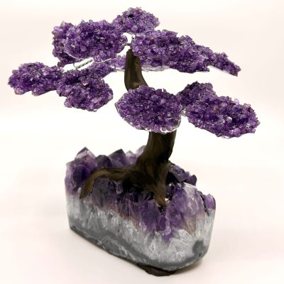 Handcrafted amethyst gemstone tree sculpture with purple crystal leaves on a natural amethyst base