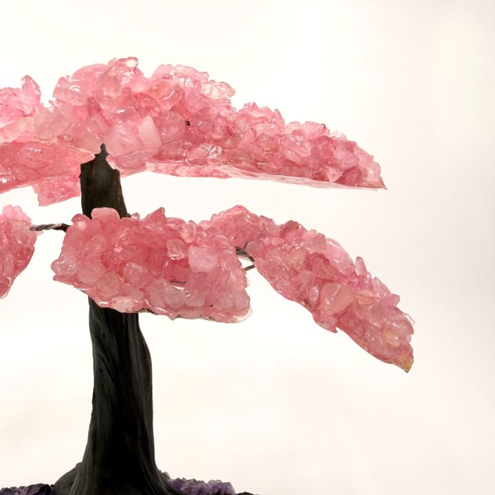 Close-up of rose quartz gemstone tree branches showcasing clustered pink crystal leaves