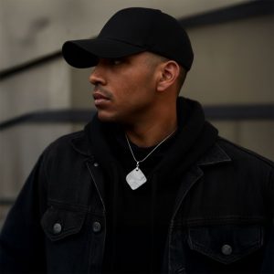 Man wearing a black cap and jacket looking to the side