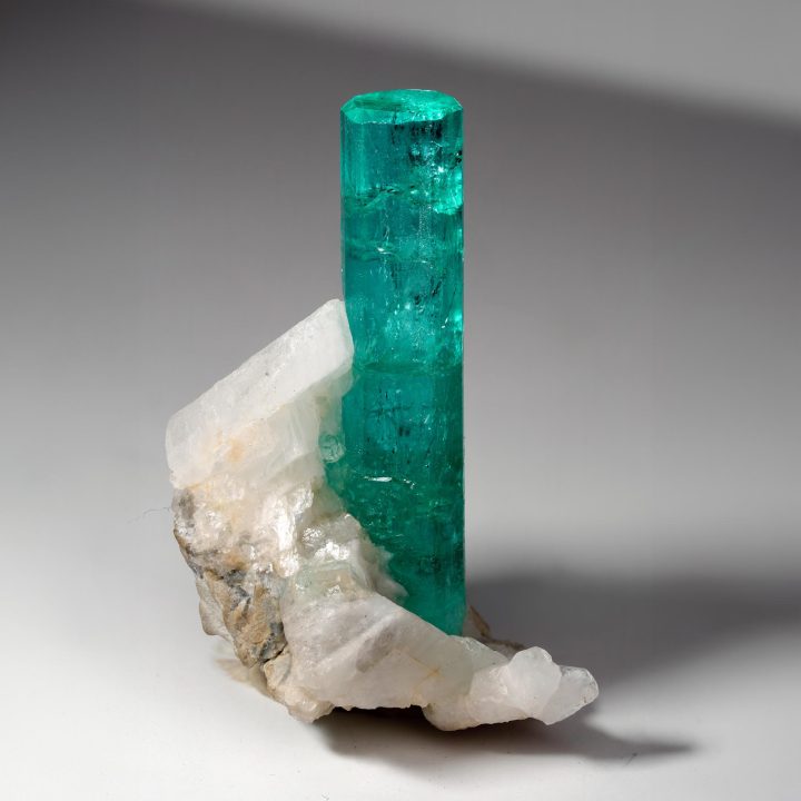 Naturally terminated Colombian Emerald crystal rising from Calcite matrix