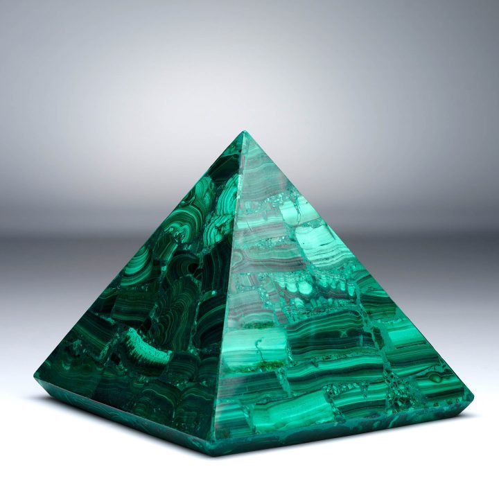 Malachite pyramid with rich emerald tones and geometric cut