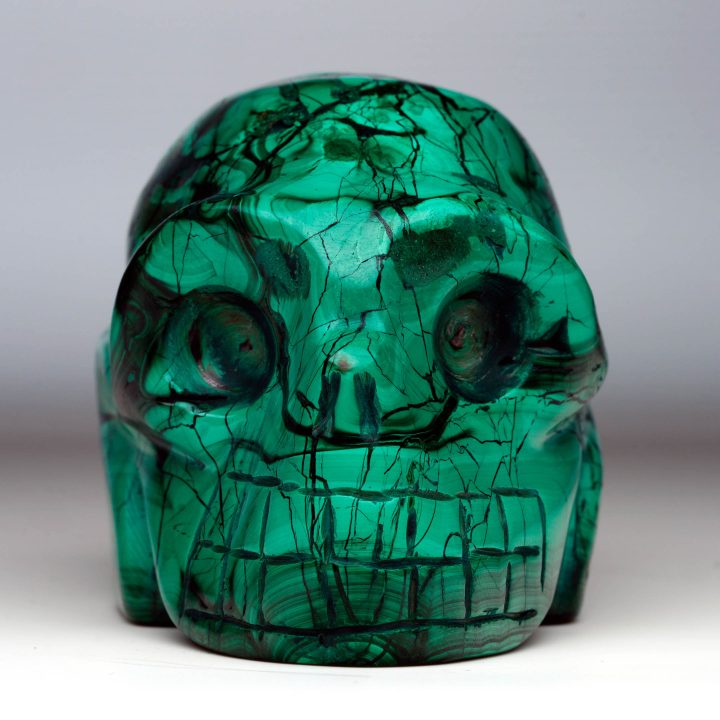 Hand-carved Malachite skull front view with natural green banding