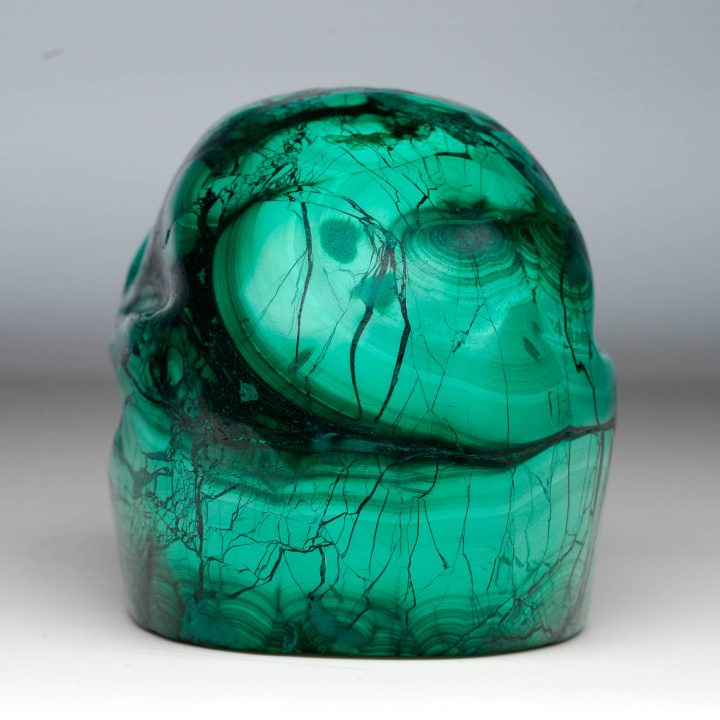 Malachite skull carving back view with natural patterns