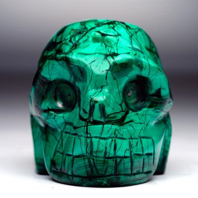 Hand-carved Malachite skull with dark green veining – front view