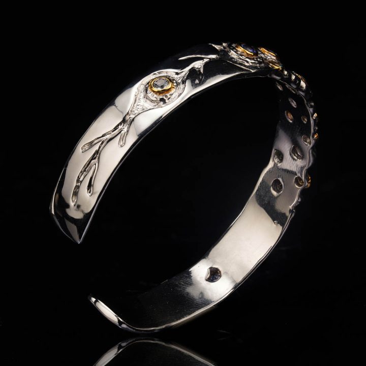 Artisan-made silver bracelet featuring mixed Tanzanite and Blue Topaz gemstones with gold highlights