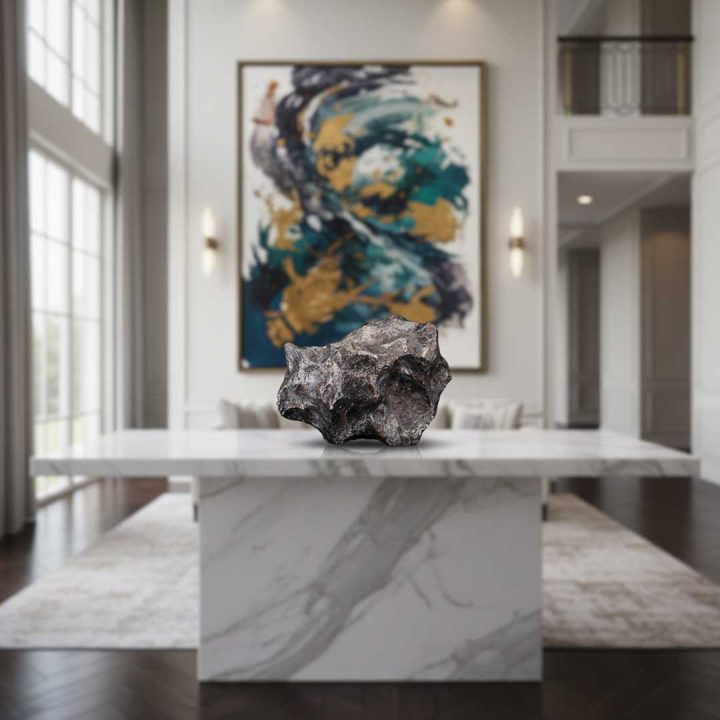 Campo del Cielo iron meteorite displayed on a marble pedestal in a modern interior, showcasing natural surface texture