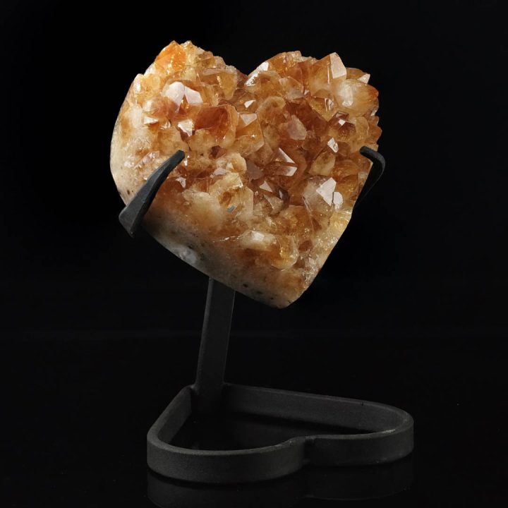 Citrine crystal heart on metal stand with warm golden tones