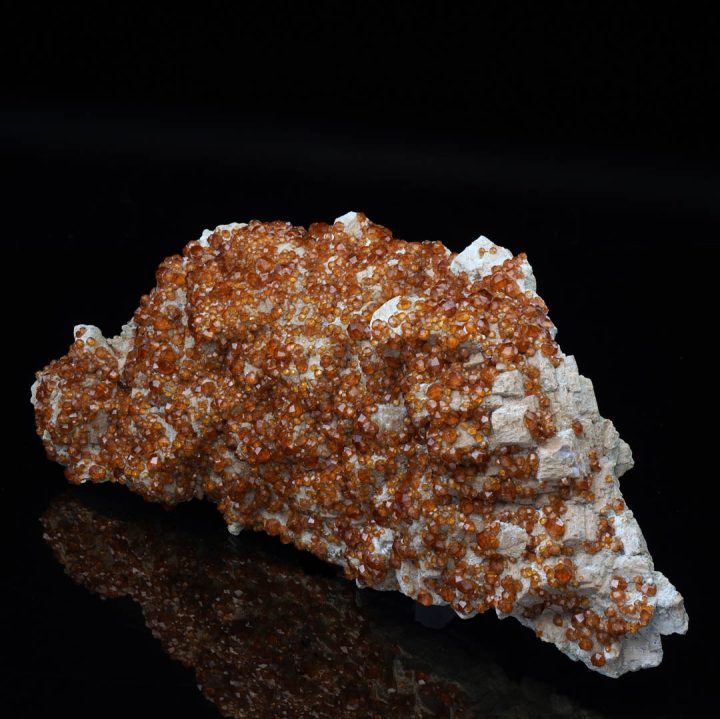 Spessartine garnet crystal cluster on feldspar matrix
