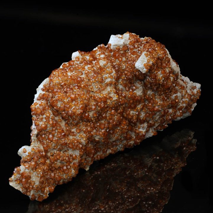 Natural spessartine garnet crystals embedded in feldspar