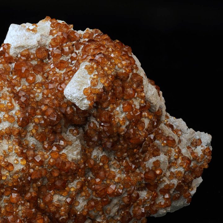 Orange spessartine garnet crystals on natural feldspar