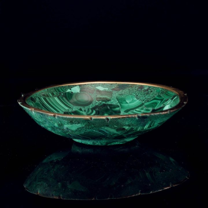 Malachite bowl with gold edge and natural green banding on dark background