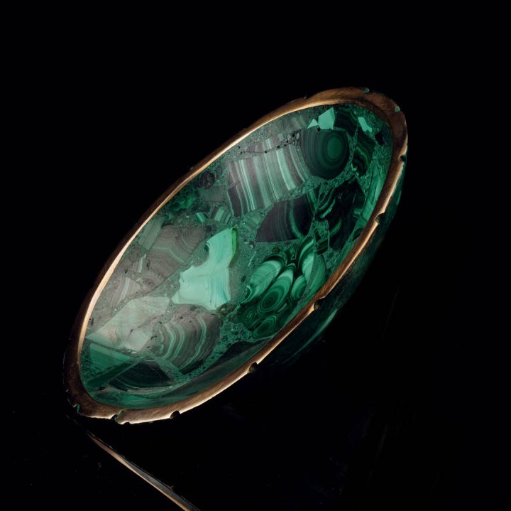 Polished malachite bowl featuring rich green patterns and gold edge