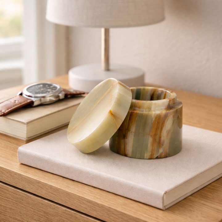 Round onyx stone box with lid displayed on a wooden nightstand, showcasing natural banded patterns and polished finish