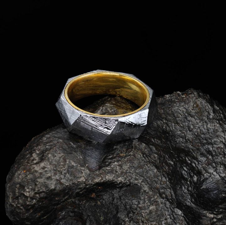 Muonionalusta meteorite ring displayed on natural stone background