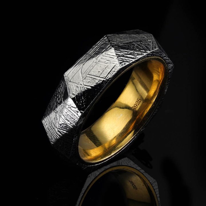 Muonionalusta meteorite ring resting on natural stone surface