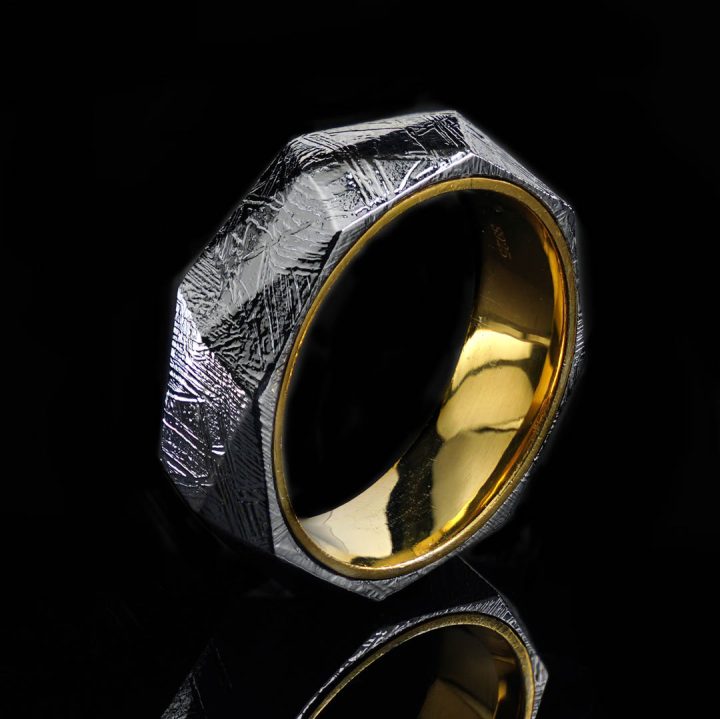Natural Muonionalusta meteorite ring displayed against dark background