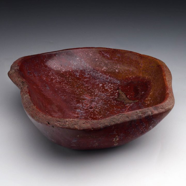 Natural red petrified wood bowl displaying fossilized wood patterns and smooth polished surface