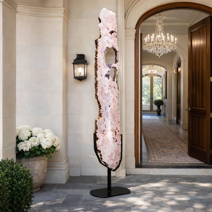 Tall pink amethyst slice on stand displayed at the entrance of a luxury home