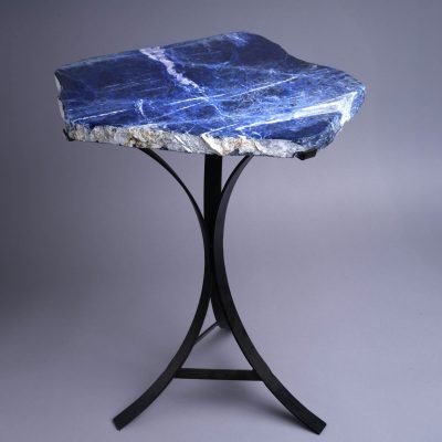 Blue stone side table with natural slab top and black metal base, showcasing rich blue tones and organic edges