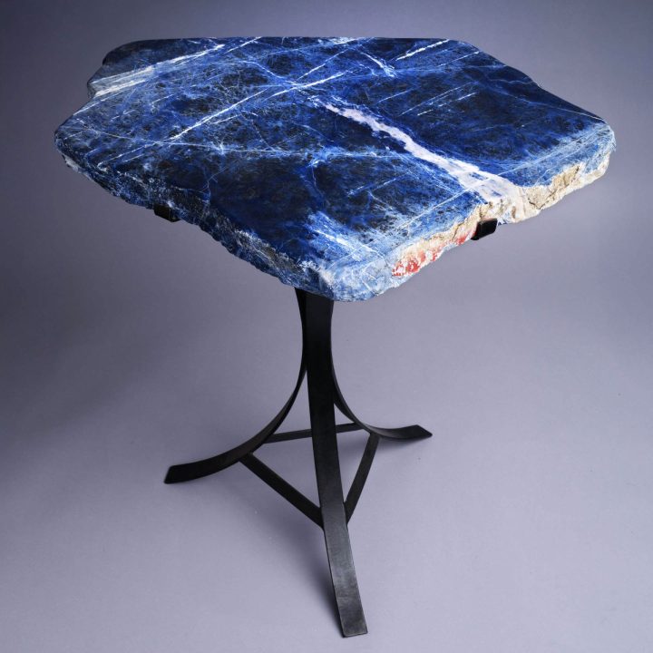 Blue stone slab side table with black metal base, showcasing natural veining and organic edges