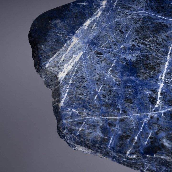Close-up of blue stone slab surface showing natural white veining and textured mineral patterns