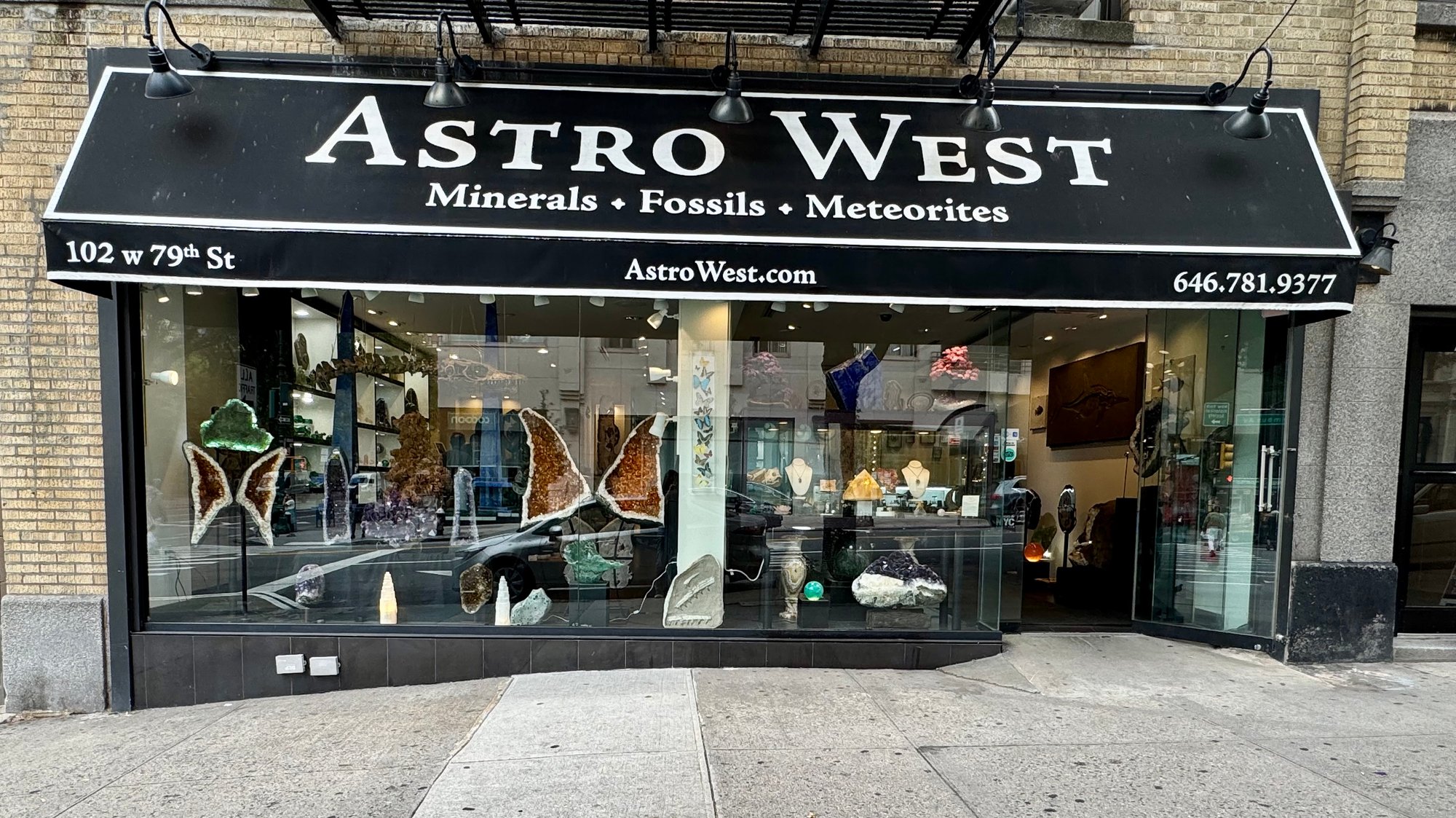 Astro West storefront on W 79th St, showcasing minerals, fossils, and meteorites in its windows.